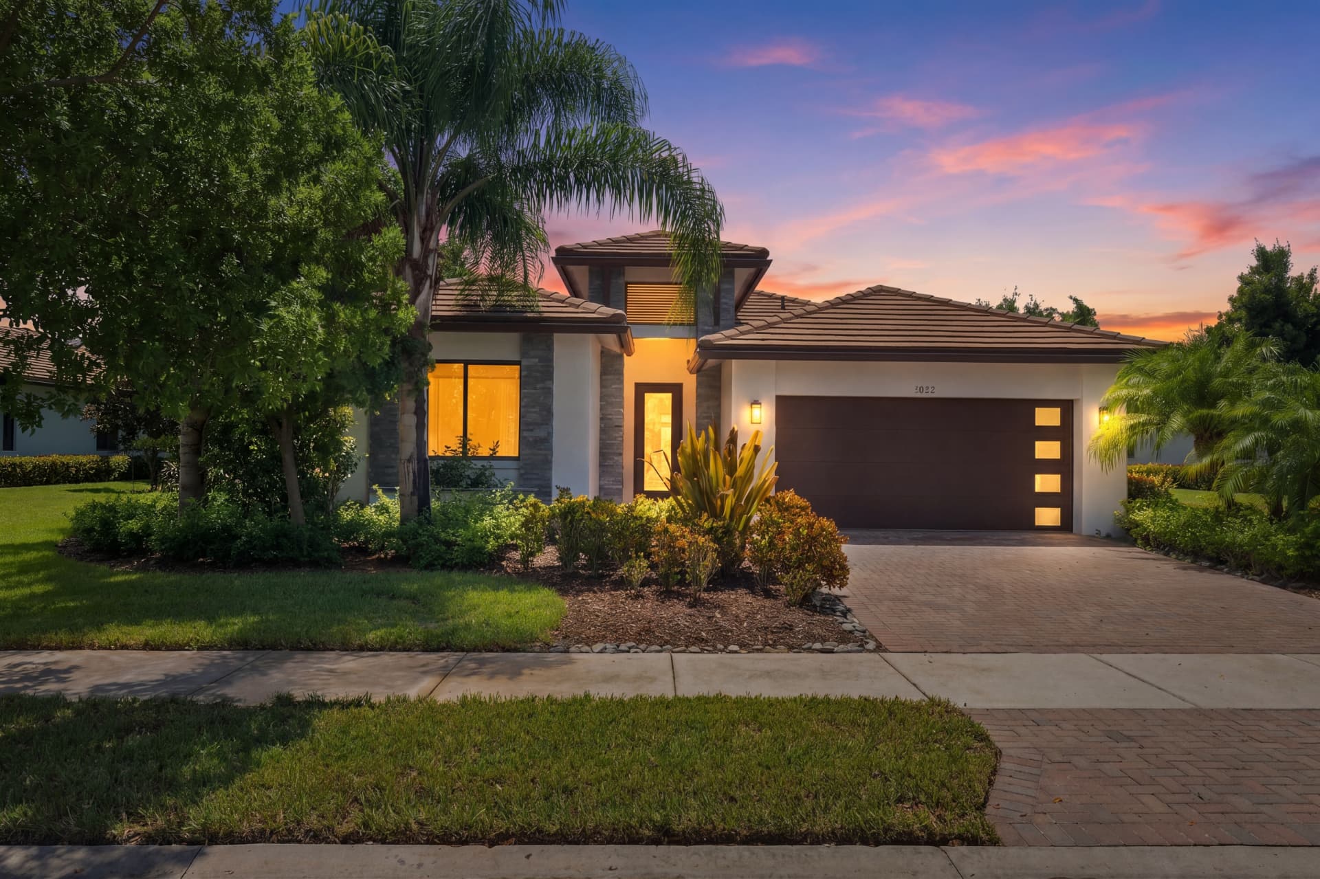 Maple Ridge model-home exterior enhanced with a twilight sky and warm window lighting